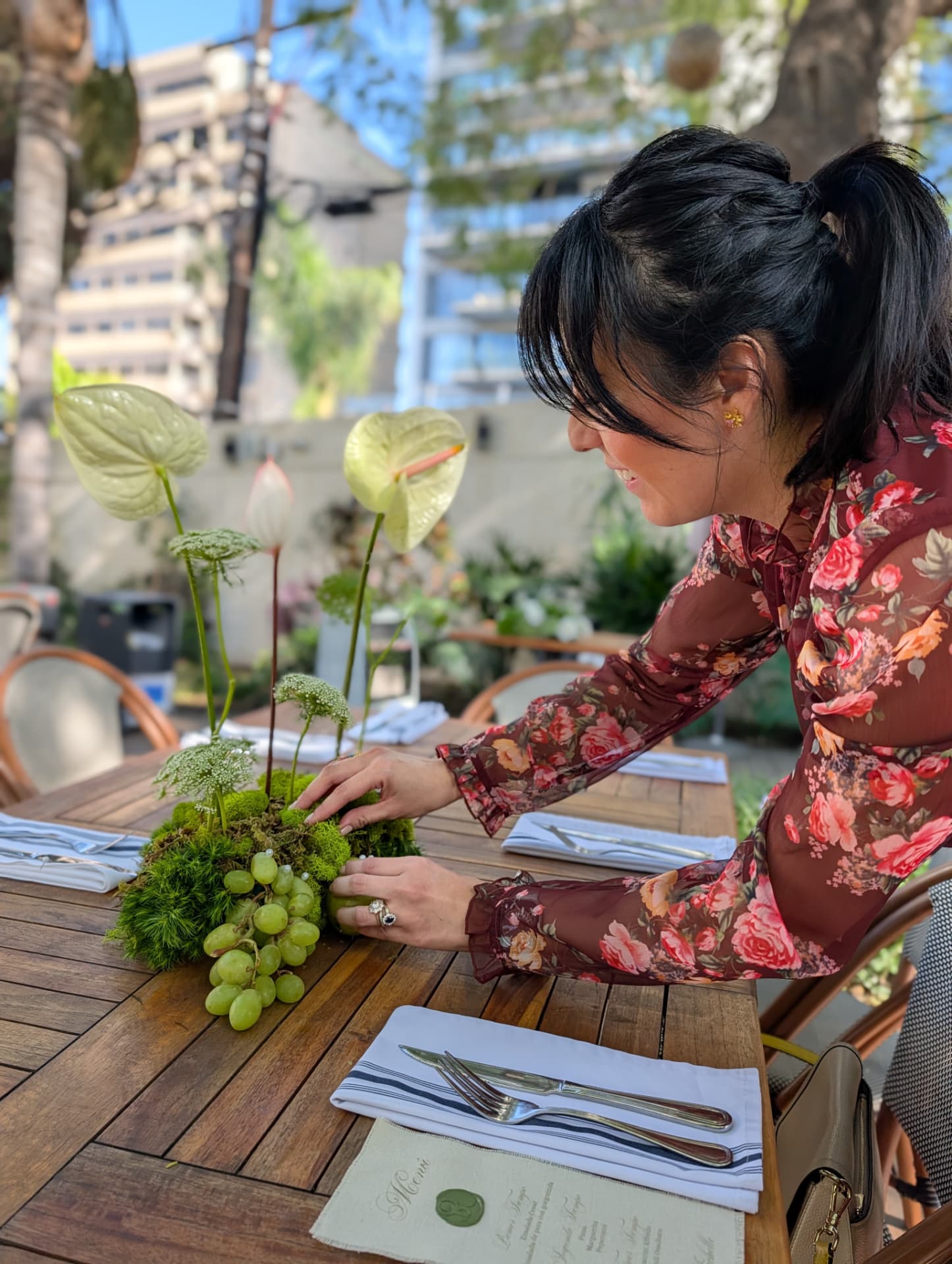 Paola Flores creando un centro de mesa con anturios, musgo y uvas